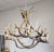 A large artist signed genuine elk antler chandelier having eight lights and a natural patina. 40/60-watt chandelier bulbs....