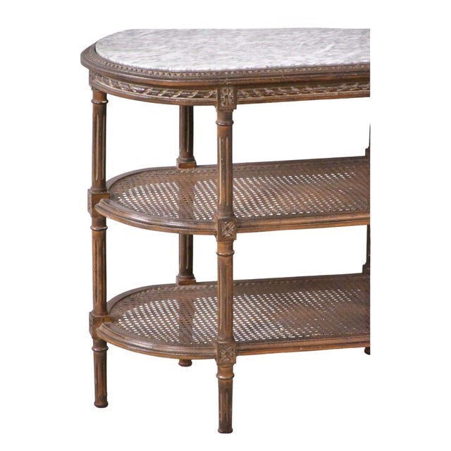 This is an antique French Louis XVI style marble and caned carved fruitwood side or drinks table. It has three caned tiers...