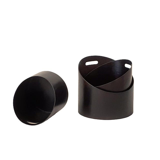 Open, slanted wooden containers made of curved beech wood, finished with a dark brown aniline finish. The practical handle...