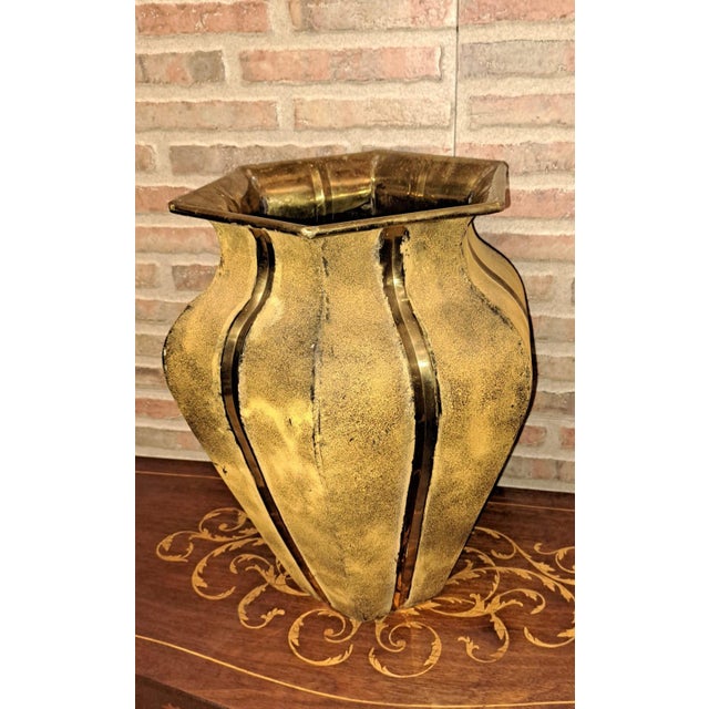 Hand-hammered brass vase in a traditional Indian style. It stands out for its stylized hexagonal shape and pronounced...