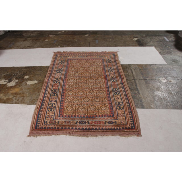 Made with hand-knotted wool originating circa 1900-1910, this antique Persian rug connotes a transitional Hamadan rug...