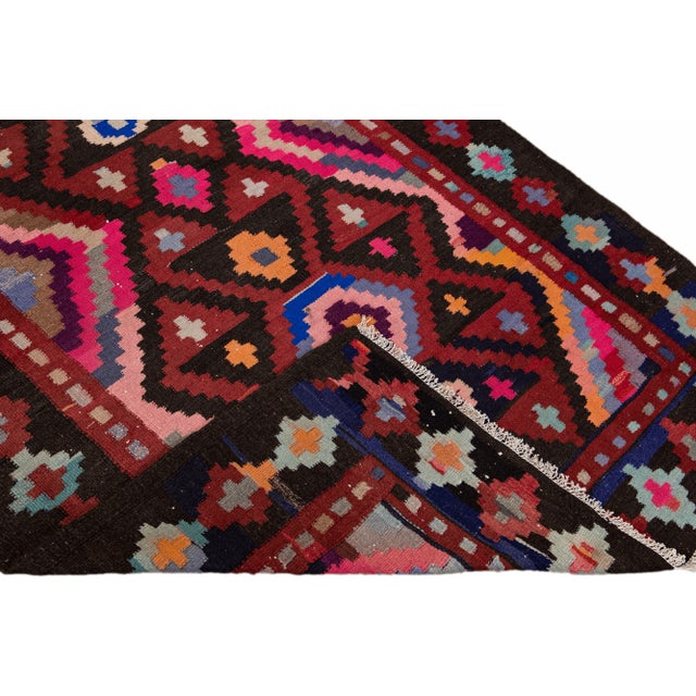 Beautiful kilim handmade wool runner with a red field. This Vintage flatweave rug features a gorgeous all-over geometric...