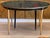This Maison Jansen dining table features a round black lacquered top with a molded edge sitting over a frieze trimmed in a...