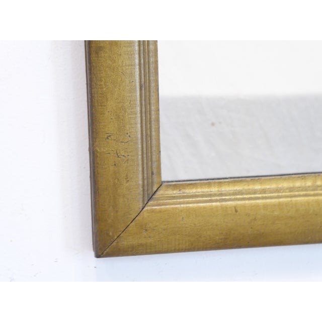 This wooden mirror with painted finish has a brass tone and measures 34.5"H x 29.5"W. It is set to hang vertically but you...