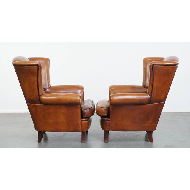 Offered is this amazing set of 2 luxurious and comfortable sheep leather ear chairs with black piping. This set of sheep...