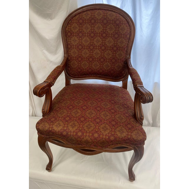 French Louis XV Style Armchair having A gorgeous wide frame in mahogany finish with padding to arms and classic burgundy...