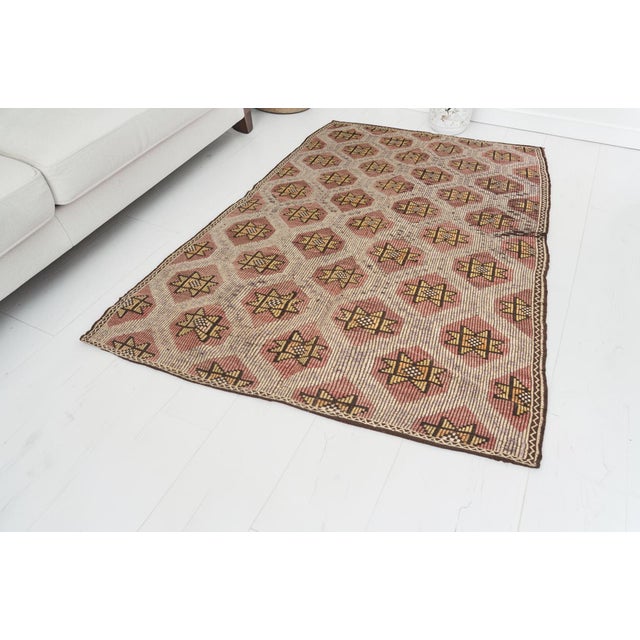 This is a vintage Turkish Oushak rug from the Mid 20th Century. The piece was hand-knotted.