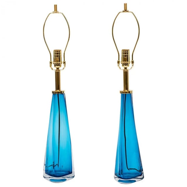 A pair of blue glass lamps with thick clear glass casing with brass hardware in the Manner of Nils Landberg for Orrefors...