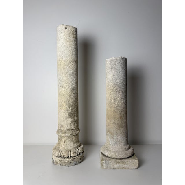 A pair of 19th-century decorative limestone columns. They feature sculpted architectural bases; the taller column has a...