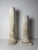 A pair of 19th-century decorative limestone columns. They feature sculpted architectural bases; the taller column has a...