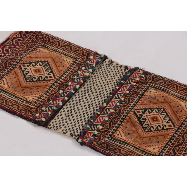 Hand-knotted in wool circa 1950-1960, this 1x3 antique tribal textile originates from Pakistan and represents a charming...