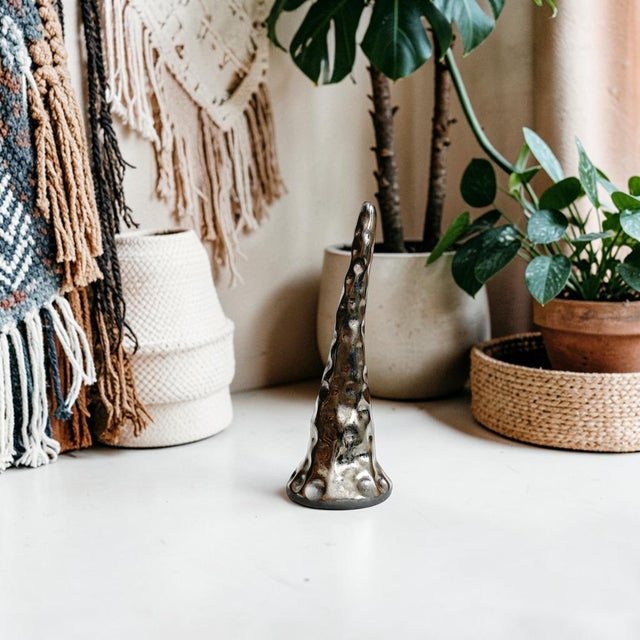 Elevate your home decor with the Metallic Black Ceramic Brutalist Ring Holder, a striking blend of modern design and...