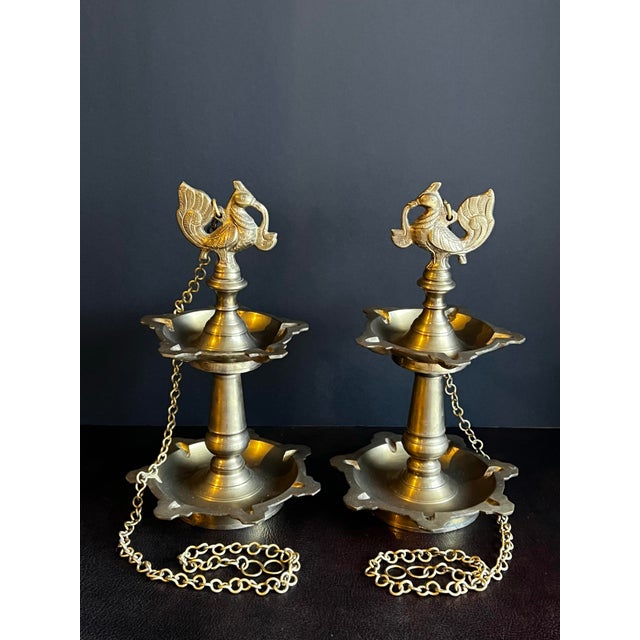 Pair of vintage brass two tiered, 12 wick, hanging peacock diyas. These high quality diyas are made of thick, golden brass...