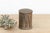 This petite cylindrical box is defined by its textured surface, featuring vertical columns of hand-hammered stylized...