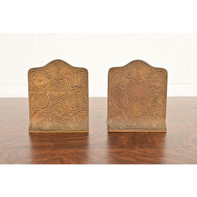 A gorgeous pair of antique Arts & Crafts or Art Deco period bronze bookends featuring Zodiac designs By Tiffany Studios...