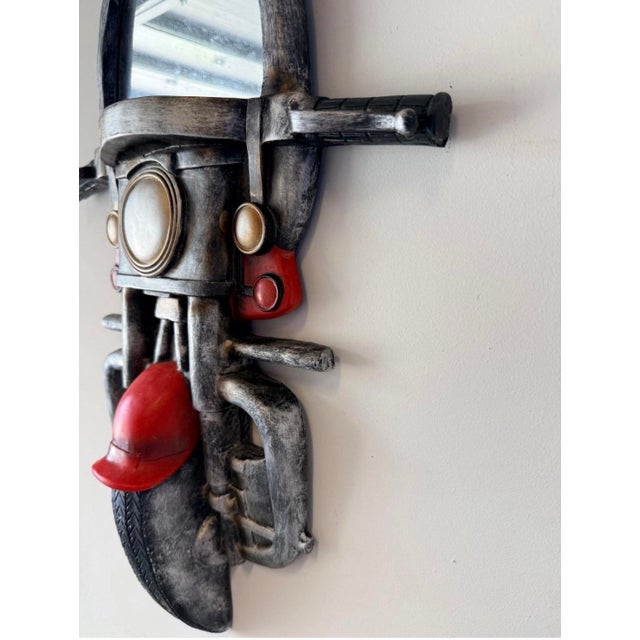This unique wall mirror features a vintage style motorcycle design with red front fender and black handlebars. The mirror...