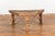 An antique rustic Indian handmade coffee table from the 19th century with trapezoidal top, iron stretchers, turned...