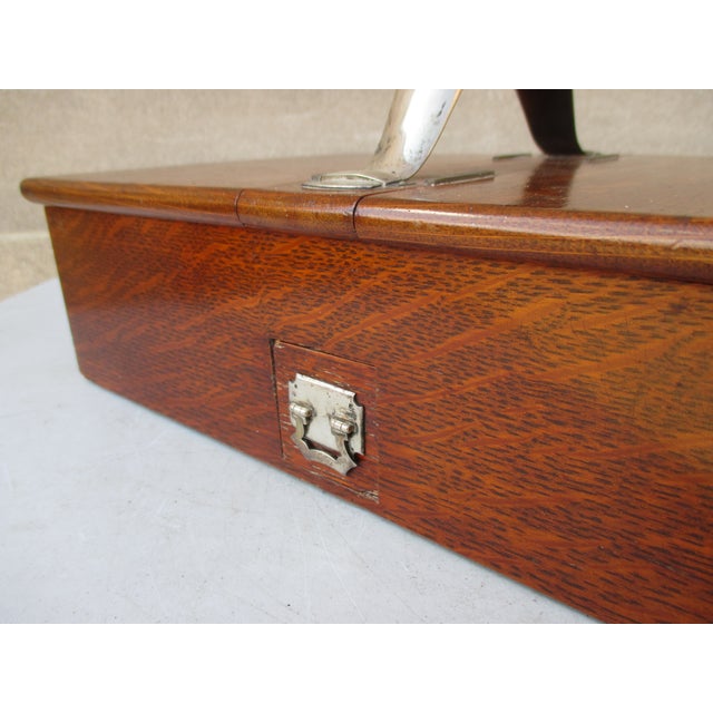 Double-lidded polished oak lockbox. Sterling silver hardware with a central handle and locking lids. Small slide-in drawer...