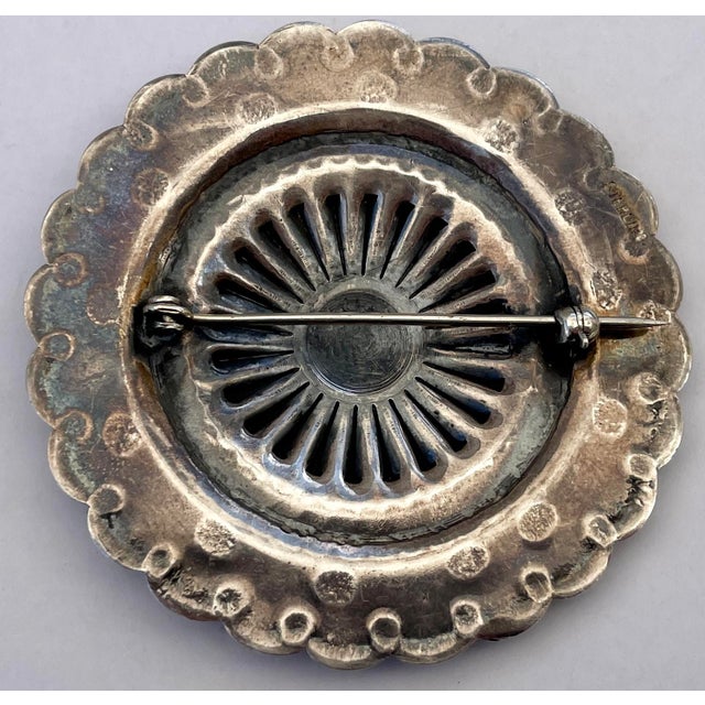 A handsome traditional Southwestern concho-style pin with a scalloped edge, radiating repose, and stamped design....