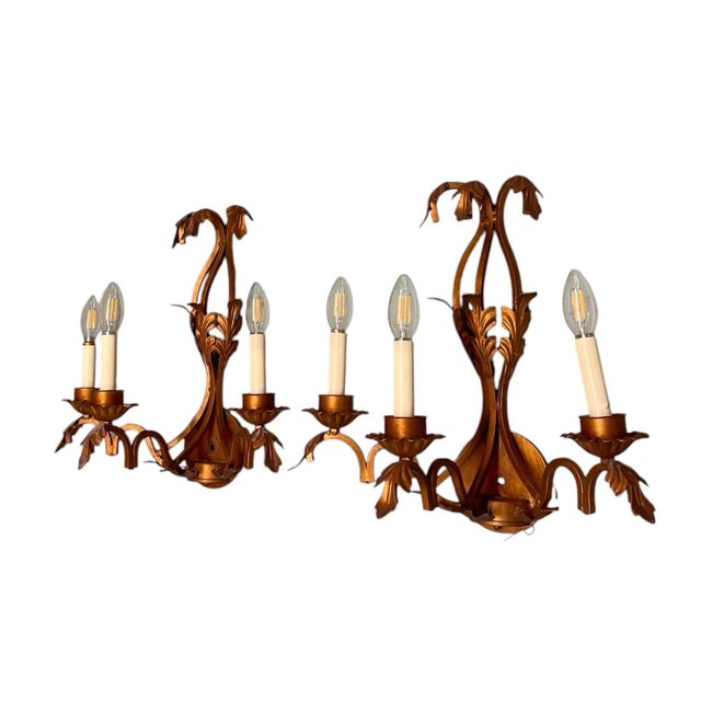 Elevate your space with this striking pair of vintage three-light wall sconces, showcasing an elegant blend of Hollywood...