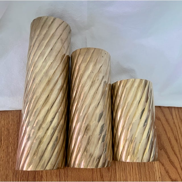 Add warmth and vintage character to your space with this striking set of three twisted brass candle holders. Each piece is...