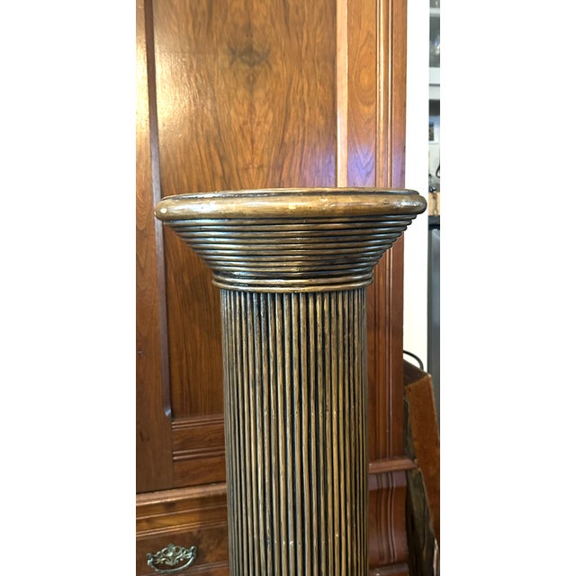 Pair of Monumental Fluted Pedestal Columns with Carved Chevron Tops A striking pair of architectural pedestal columns...