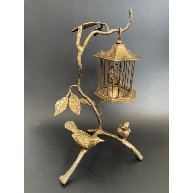 This intricate solid brass sculpture features two birds resting at the base of a tree, with slender, flowing branches and...