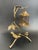 This intricate solid brass sculpture features two birds resting at the base of a tree, with slender, flowing branches and...