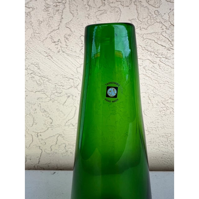 Handmade green glass art by Tarnowiec. Tall being 14” the base is 5.5” in diameter and the top is about 1”. There is a...