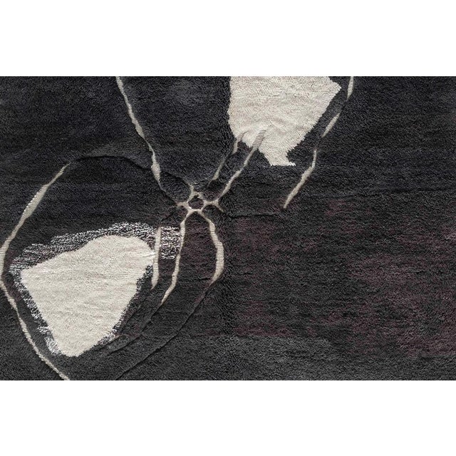 Elevate your interior with this striking 307 x 206 cm hand-knotted wool rug, crafted in dramatic shades of charcoal and...