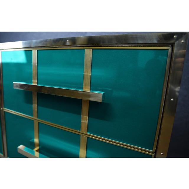 Italian aqua-blue Murano glass chest of drawers with polished brass details. Four drawers are arranged in a two-by-two...