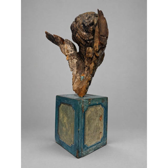 A dramatic antique Continental carved cherub fragment, modeled as a winged putto head or angelic bust mounted on a later...