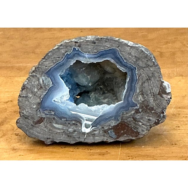 Formed with concentric crystalline rings and vivid lapis-blue banding, this natural agate quartz geode specimen reveals a...