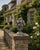An evocative early 20th-century garden ornament modeled as a classical urn overflowing with an abundant arrangement of...