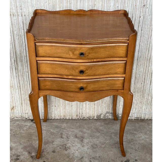 A French oak bedside tables with three drawers from early 20th century. This French 'table de chevet' features a...
