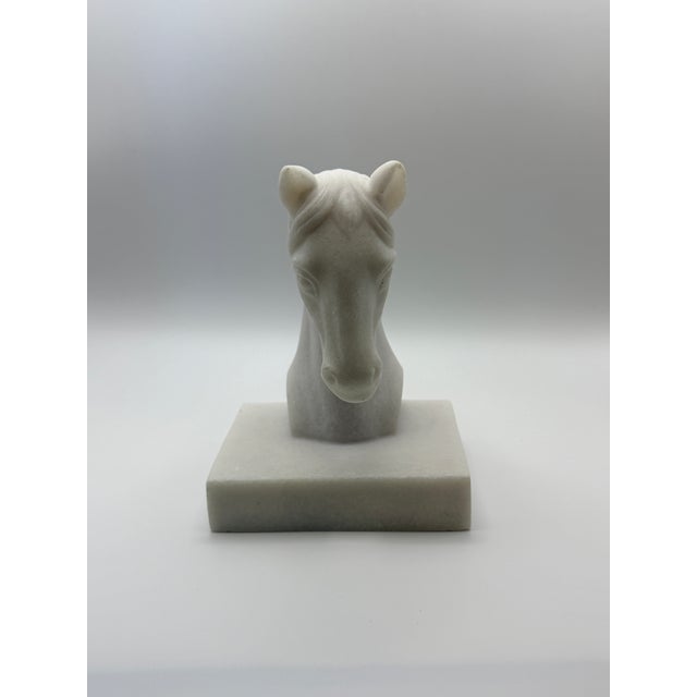 A handsome sculptural horse head bookend carved from natural white stone and set on a substantial rectangular base....