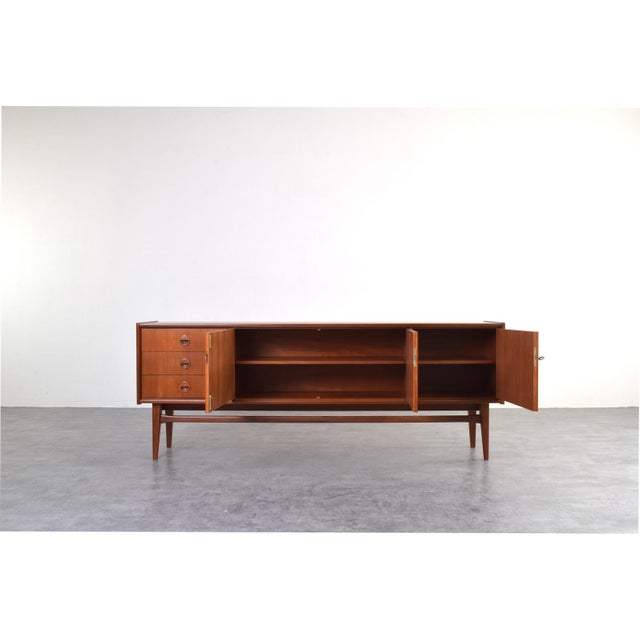 This teak sideboard model Premium by Bartels is the essence of mid-century modern style and solid German craftsmanship...