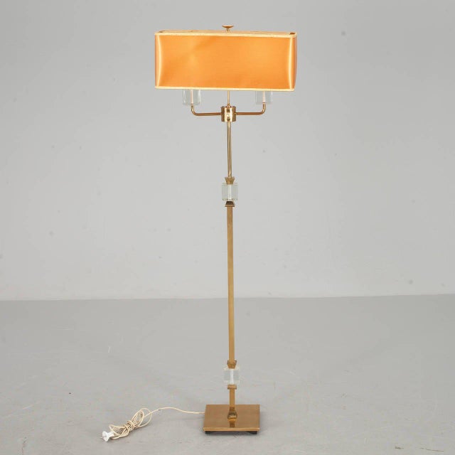 A floor lamp by Malmo metal product company, Sweden, circa 1950. Brass and glass. Shade not included. Existing European...