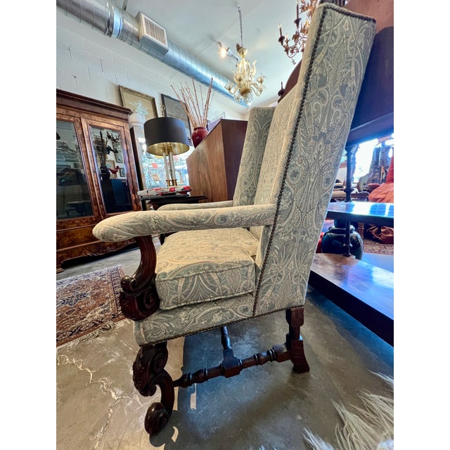 Newly reupholstered pair of William & Mary style high-backed base chairs. Beautiful wood carvings adorn the bottoms of the...