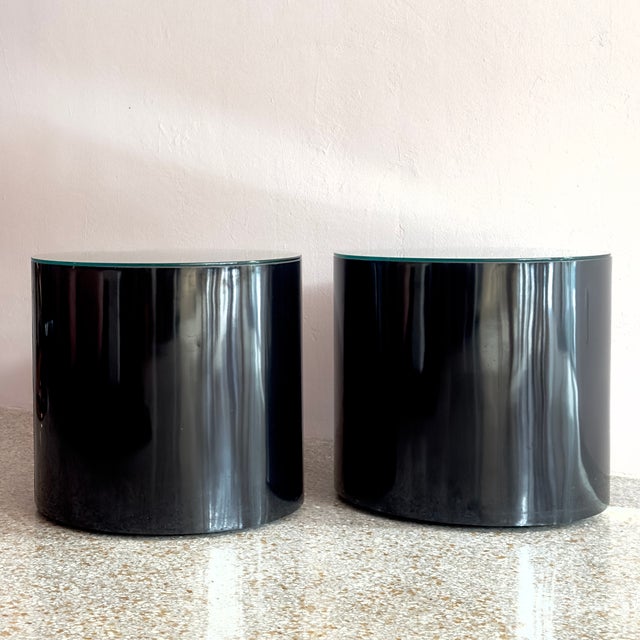 These Postmodern Glass-Top Black Lacquer Cylinder Side Tables offer a sleek, minimalist aesthetic that anchors any...