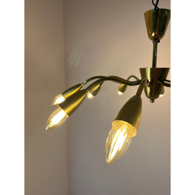 This ten-arm chandelier from the 1950s captivates with its striking spider-like design and is an impressive example of the...