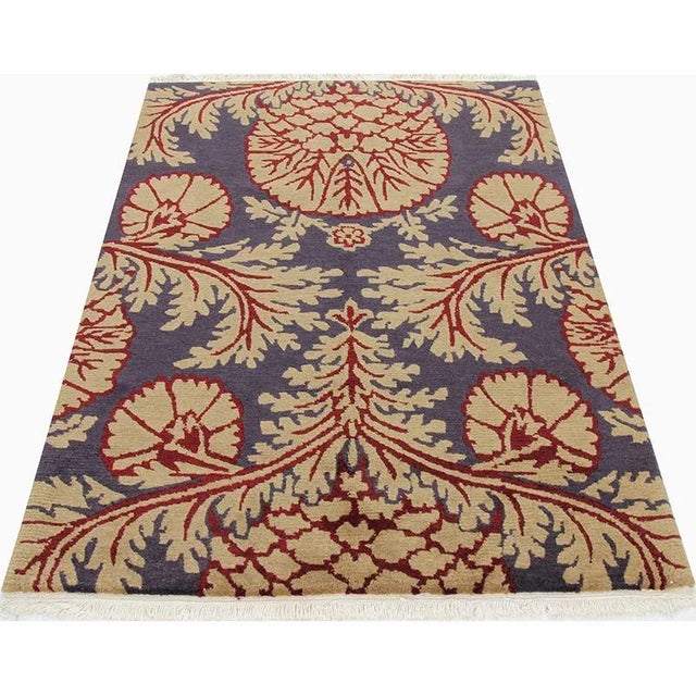 Handwoven Tibetan rug with an eggplant-colored background, accented with shades of maroon and blush. Hand-woven from a...