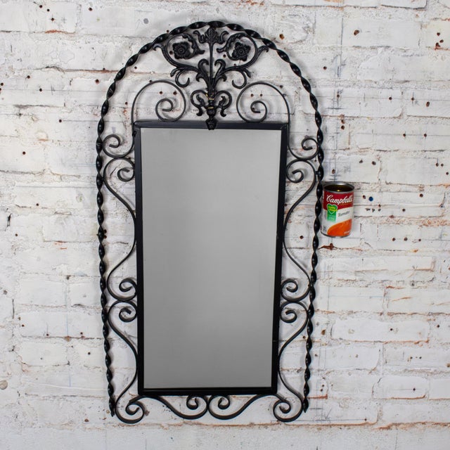 Marvelous vintage Art Deco or Art Nouveau wall mirror composed of a black painted hand formed wrought iron frame & cast...