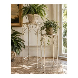 Pair of Vintage Indoor/Outdoor Hollywood Regency Graduated Metal Plant Stands, Distressed Ivory Scrollwork For Sale