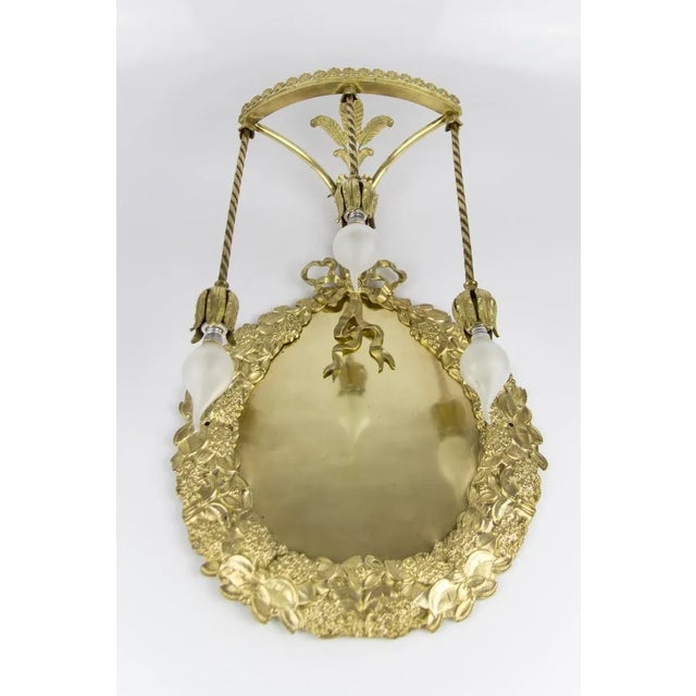 Marvelous and very unusual Louis XVI style bronze and brass wall sconce. Decorated with a laurel wreath, which is tied...