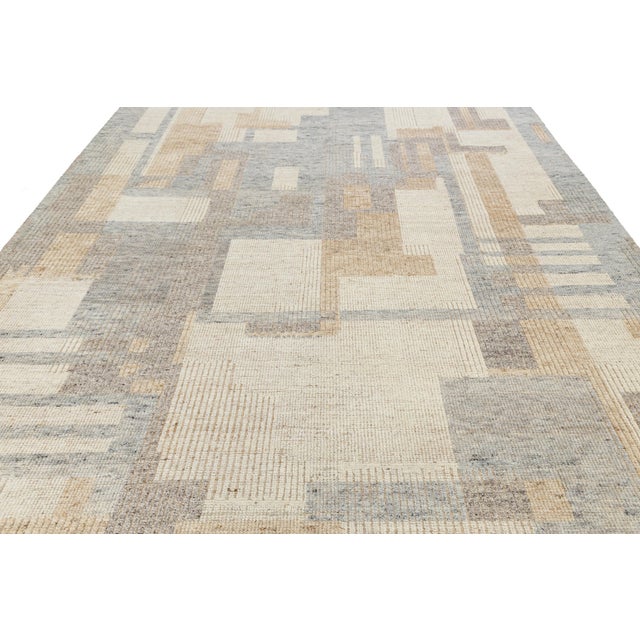 This modern Moroccan-style wool rug features a sophisticated patchwork of abstract rectangles in muted beige, cream, and...
