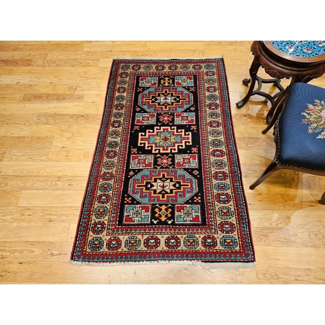 This exceptional mid-20th century vintage Persian Kurdish area rug features a striking geometric medallion design...