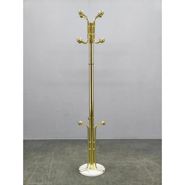 Elegant Italian modern coat rack produced in the 1970s featuring a polished brass-plated metal construction with...