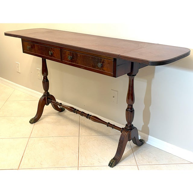 English Regency style drop-leaf console table from the mid 20th century. The piece is beautifully constructed of mahogany...
