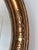 Antique oval beveled mirror in neoclassical style, dating to the late 19th century. Crafted from wood with a gesso layer...